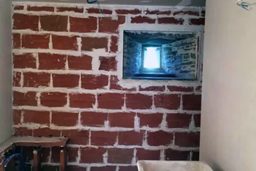 Construction d'un mur en brique rouge avce fenetre